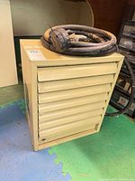 Front view showing louvered grille, power cable coiled on top