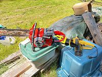 Overall view of both chainsaws outdoors on storage totes
