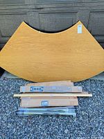 front view of curved tabletop with bundled legs and support pieces