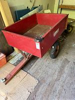 Full view of red steel Lambert wagon with tow bar attached