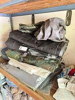 Stacked folded tarps on shelf showing multiple colors