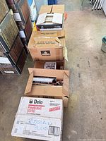 Four cardboard boxes filled with assorted hardcover books