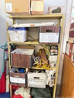 Full view of metal shelving unit loaded with boxes, ropes, hardware
