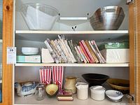 Overall view of cabinet shelves showing majority of lot items
