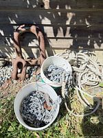 Lot overview with two buckets of chain, two large shackles, rope coil