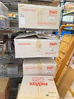 Stack of four branded audio component boxes on shelf: two Nakamichi, one Nakamichi Receiver 2, one ReVox