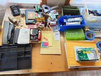 Overview of entire lot on tabletop showing organizer, stapler, stamps, notepads, envelopes and assorted supplies