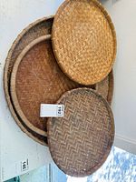 Three stacked woven bamboo trays showing sizes and weave
