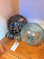 Group of four aqua glass fishing floats, two small, one medium, one large with rope