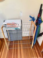Overall view of shoe rack with boot tray, shoe care kit on top, umbrellas to side