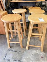 Four solid wood backless bar stools grouped together