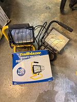 Two Trailblazer work lights and original box on workshop floor