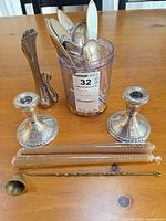 Lot overview with flatware in container, candlesticks, swan vase, candles, snuffer