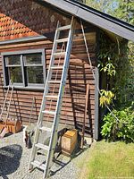 Full view of Werner aluminum extension ladder leaned against building