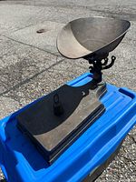 Full view of cast iron platform scale on blue bin