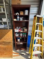 Full view of tall brown bookshelf in storage unit