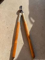Full view of bypass lopper with wooden handles and metal bypass head