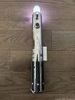 full view of lightsaber hilt laying on floor, light on