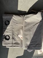Folded beige grommet curtain panels