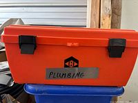 Closed orange toolbox labeled Plumbing