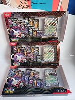 Two opened Paldean Fates Great Tusk ex boxes showing booster packs, foil promo cards and oversized cards