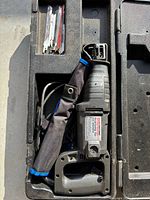 Reciprocating saw inside opened case with blades visible