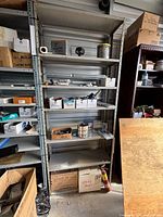 Full view of grey metal shelving unit with five shelves