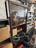 Front view of wood cabinet showing glass sliding doors and shelf