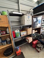 Full view of gray metal shelving unit showing five shelves and steel uprights