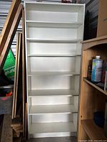Front view of tall white bookcase with six shelves