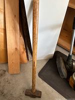 Full view of sledgehammer showing wood handle and steel head