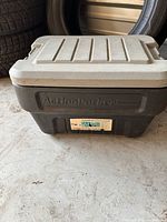 Full view of closed ActionPacker container, black base, gray lid, label visible
