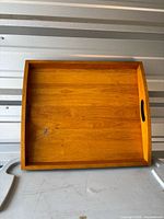 Top view of wooden tray showing interior surface and side handles