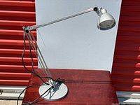 Full view of IKEA adjustable desk lamp on table showing base, arm and shade