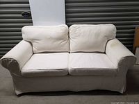 Front view of white Ikea loveseat with two seat and two back cushions