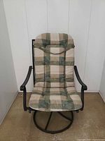 Front view of chair with plaid cushion on metal swivel base