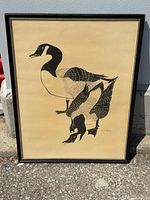 Full view of framed Canadian geese artwork leaning on wall