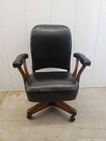 Front view of black vinyl and wood swivel office chair