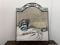 Front view of painted metal winter scene wall hanging