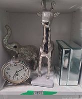 Group shot showing clock, elephant, giraffe, mirrored box on shelf
