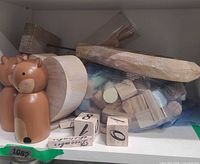 Shelf view showing two wooden foxes, loose wood blocks, numbered cubes