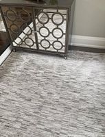 Close view showing rug pattern beside mirrored cabinet