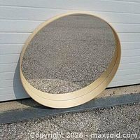 Mirror leaning against exterior wall showing full front view and bamboo frame