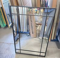 Front view of rectangular mirror showing full metal frame and grid bars