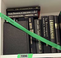 Shelf showing black & gold spines including Family Blessings, The Blessings of..., The 10-Second Kiss, plus lower row assorted titles.
