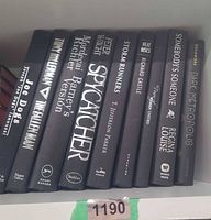 All nine black hardcover books with silver lettering visible on shelf