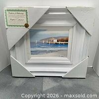 Front view of framed sailboat painting with corner protectors