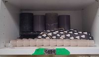 Shelf with grey pillars, beige small pillars, and black taper candle bundle