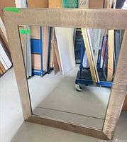 Front view of mirror showing champagne textured frame and reflective glass