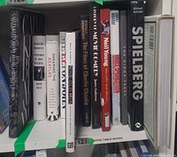 Shelf view of ten music and film-themed coffee table books